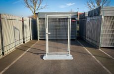 Tijdelijke inlooppoort voor bouwhekken voorzien van een slotkast, zichtplaat en vlakke voetplaat tegen struikelen.